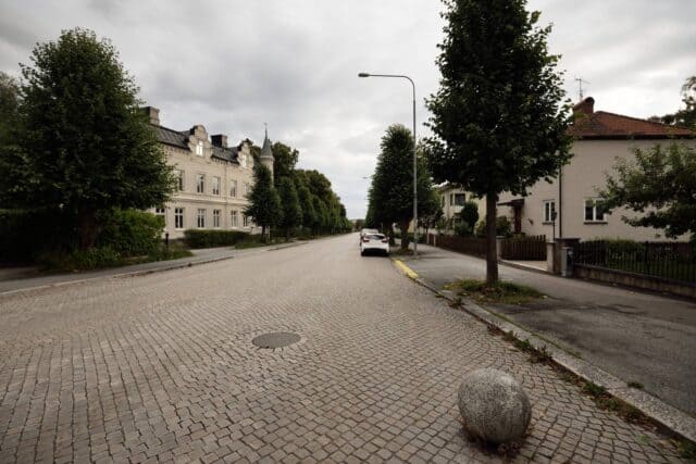 Tom bilgata med en bil parkerad på högersida av vägen i Enköping