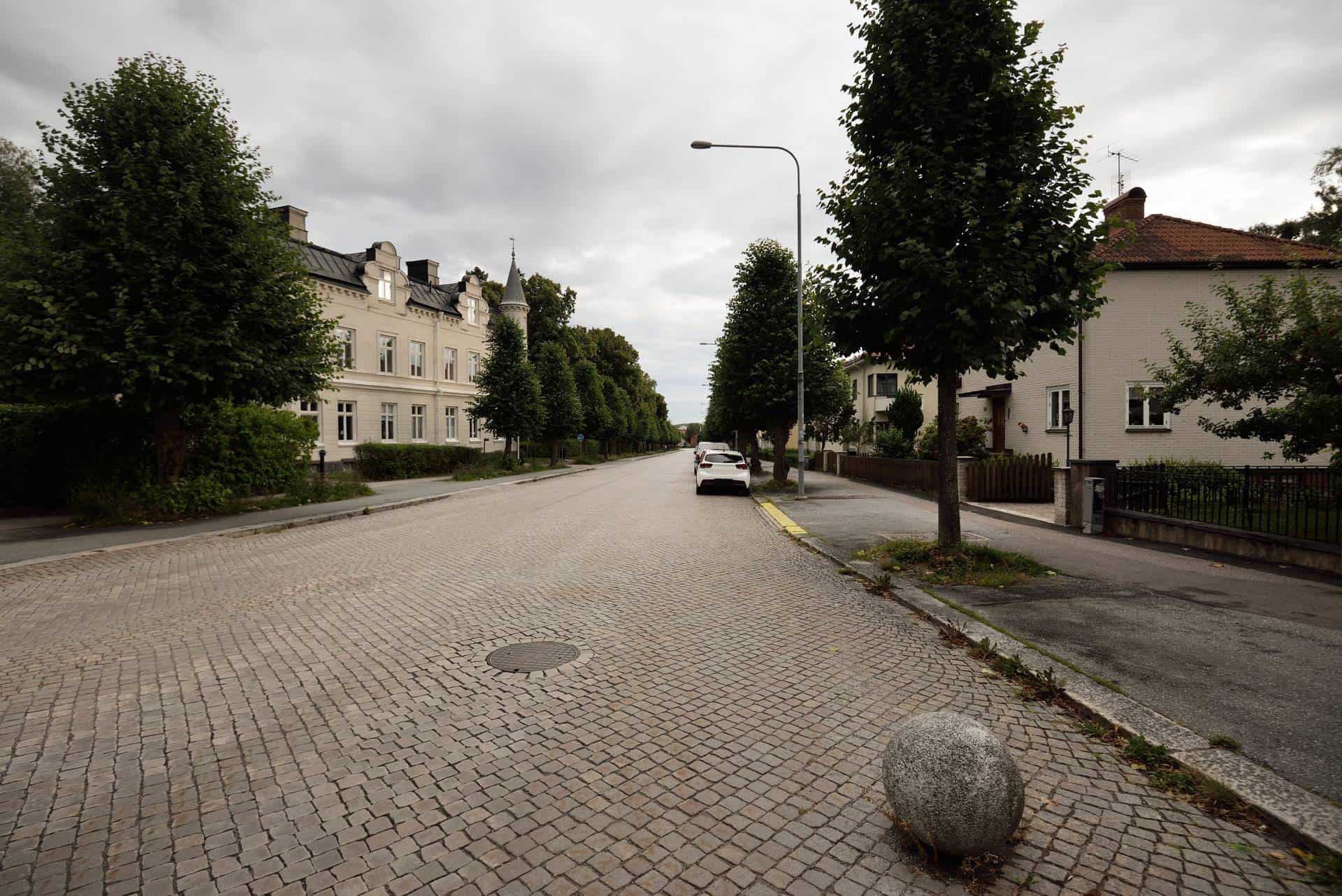 Tom bilgata med en bil parkerad på högersida av vägen i Enköping